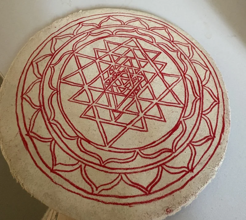 Sri Chakra design drawn in red on a prepared round board